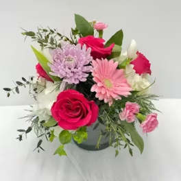 Mixed bouquet of pink and white flowers in a dark vase