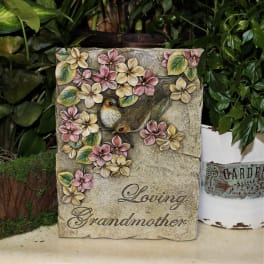 Decorative stone plaque with flowers, birds, and the words Loving Grandmother