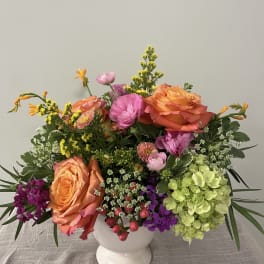 Colorful mixed bouquet in a white pedestal vase