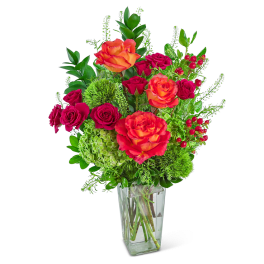 Bouquet of orange and pink roses in a clear glass vase