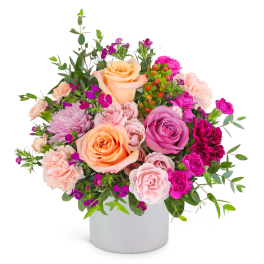 Mixed pink and peach flower arrangement in a white vase