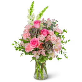 Pink roses and carnations in a clear glass vase with white snapdragons
