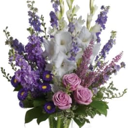 Purple and white mixed bouquet in a clear glass vase