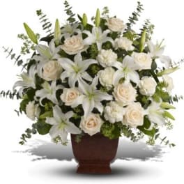 White lilies and roses arranged in a brown vase
