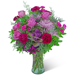 Pink and purple bouquet of roses, carnations, and chrysanthemums in a glass vase