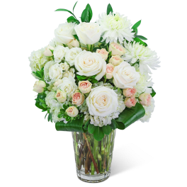 White roses and chrysanthemums in a clear glass vase