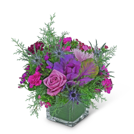 Pink and purple floral arrangement in a clear square vase