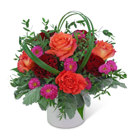 Orange and red roses with pink daisies in a white vase