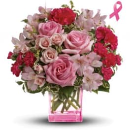 Pink roses and carnations in a pink glass vase with a ribbon symbol