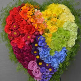 Heart-shaped rainbow floral arrangement on a stand