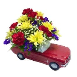 Colorful flower arrangement in a red car-shaped container