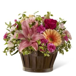 Mixed pink and peach flowers in a wooden basket