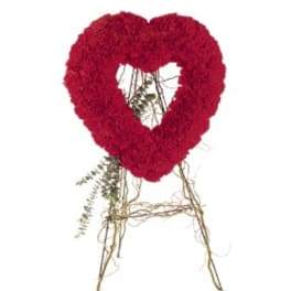 Standing red heart-shaped floral wreath on a rustic twig easel