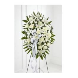 White funeral spray on a standing easel with ribbon