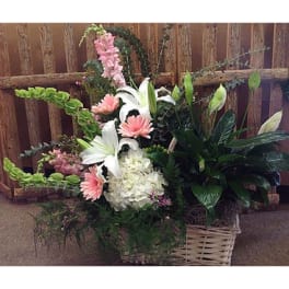 Basket arrangement with white lilies, pink daisies, and hydrangea
