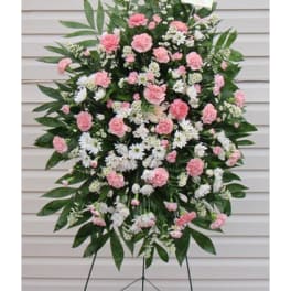 Standing floral spray with pink and white carnations on a metal easel