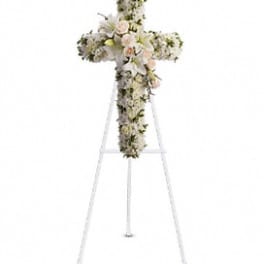 White floral cross on a stand with pale pink accents