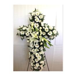White floral cross standing on an easel