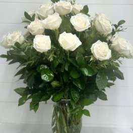 Tall arrangement of white roses in a clear glass vase