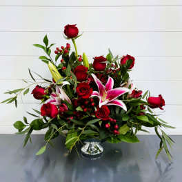 Red roses and pink lilies arranged in a silver vase