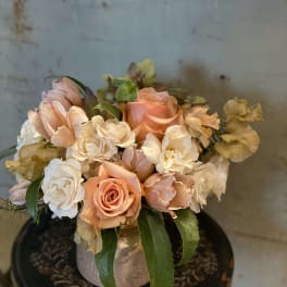 Peach and white roses arranged in a low vase