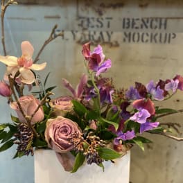 Pink roses and purple sweet peas in a white vase