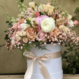 Pastel flower arrangement in a white hat box with a satin ribbon