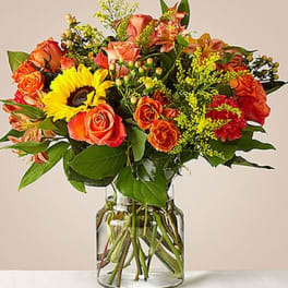 Orange and yellow mixed bouquet in a clear glass vase