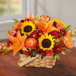 Basket arrangement with sunflowers, orange lilies, and roses