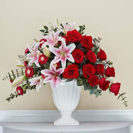 Red roses and pink lilies arranged in a white vase