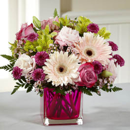 Pink and white mixed bouquet in a magenta glass vase