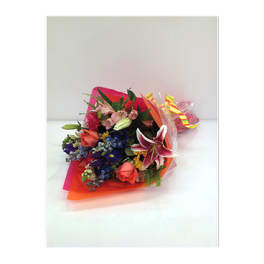 Colorful bouquet with lilies and roses wrapped in bright paper