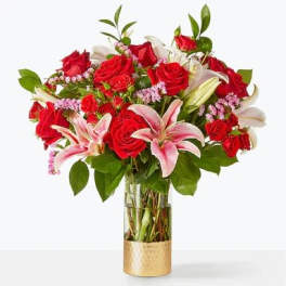 Bouquet of red roses and pink lilies in a glass vase
