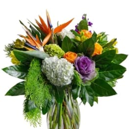 Mixed bouquet with orange and purple flowers in a glass vase