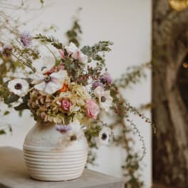 Loose bouquet of white and pink flowers in a white vase