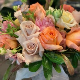 Bouquet of peach, blush, and cream roses with pink blooms