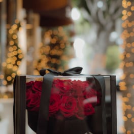 Box of red roses tied with a black ribbon