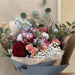 Mixed bouquet of red and pink roses with small white filler flowers