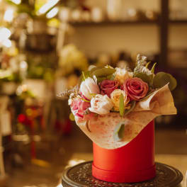Bouquet of pink and white roses in a red hat box