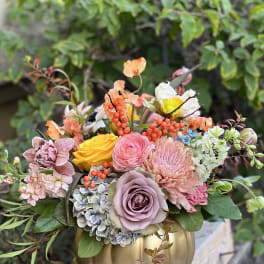 Mixed pastel bouquet in a gold pumpkin vase
