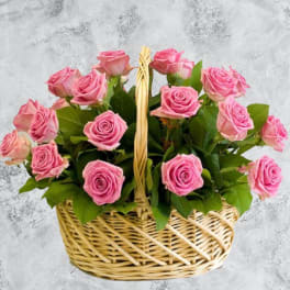 Basket of pink roses with green leaves
