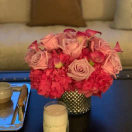 Pink rose arrangement in a textured silver vase on a table