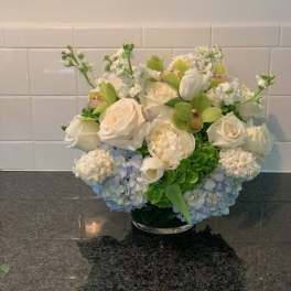White and blue floral arrangement in a low vase