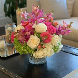 Pink and white rose bouquet with orchids in a glass vase