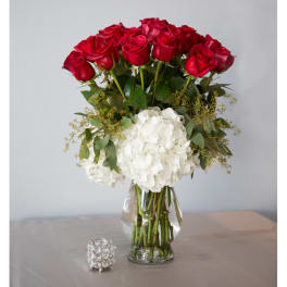 Red roses and white hydrangeas in a clear glass vase
