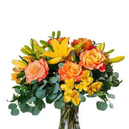 Bouquet of orange roses and yellow lilies in a glass vase