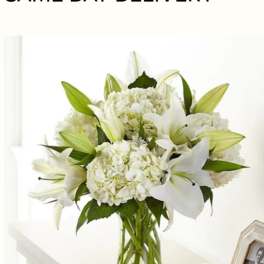White lilies and hydrangeas in a clear glass vase