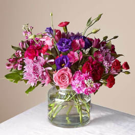 Pink and purple mixed bouquet in a clear glass vase
