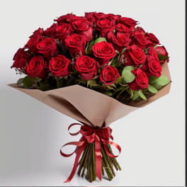 Bouquet of red roses wrapped in beige paper with a red ribbon
