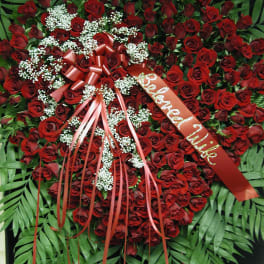 Heart-shaped red rose wreath with ribbon and white baby's breath